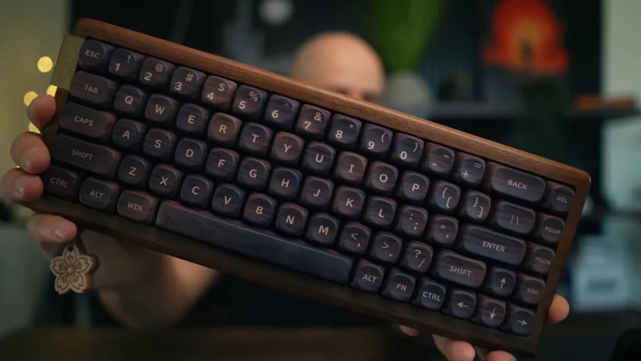 Front view of the compact walnut keyboard with rounded dark keycaps