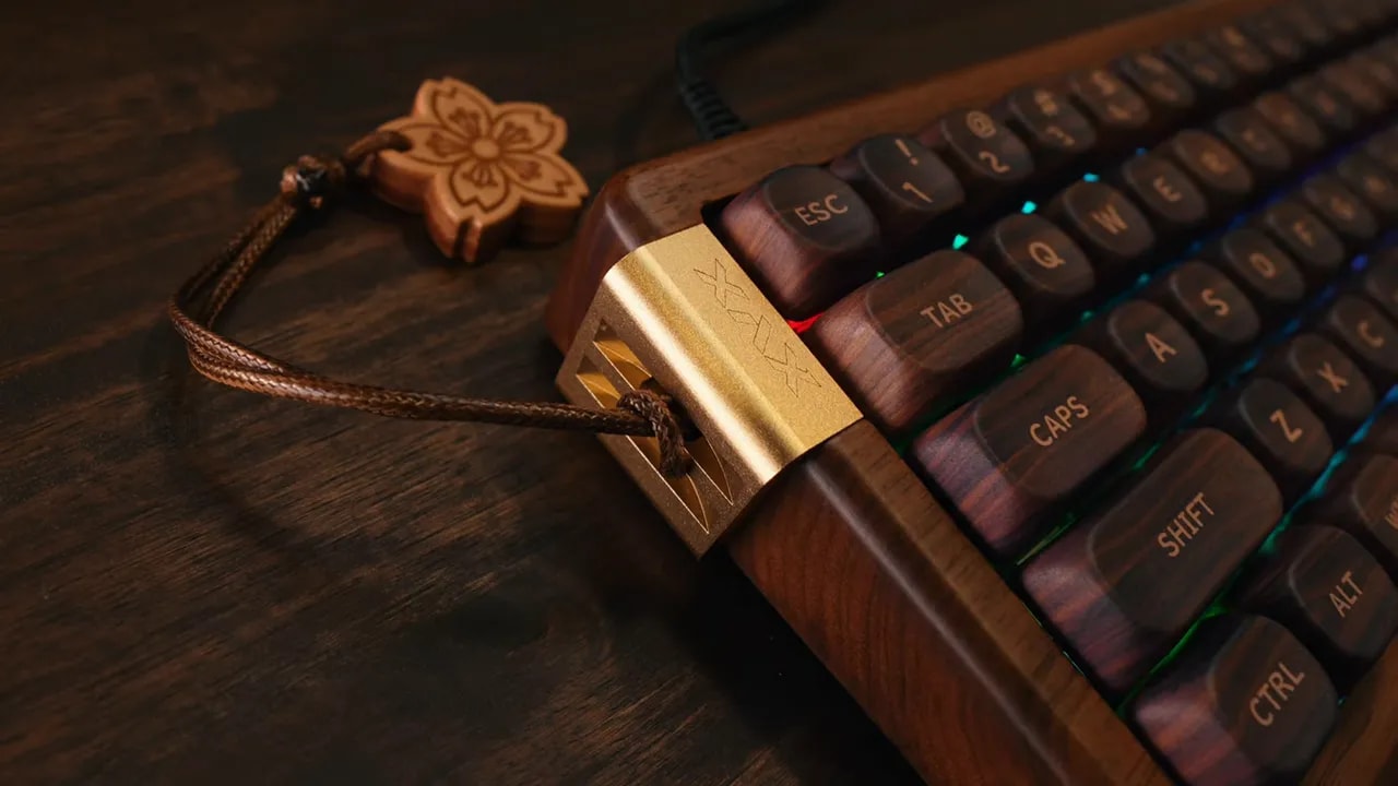 Gold metal side accent, cable port, and Sakura charm on walnut keyboard