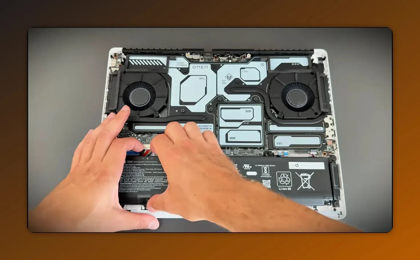 Hands unplugging the internal battery connector on an HP Omen Max 16 laptop