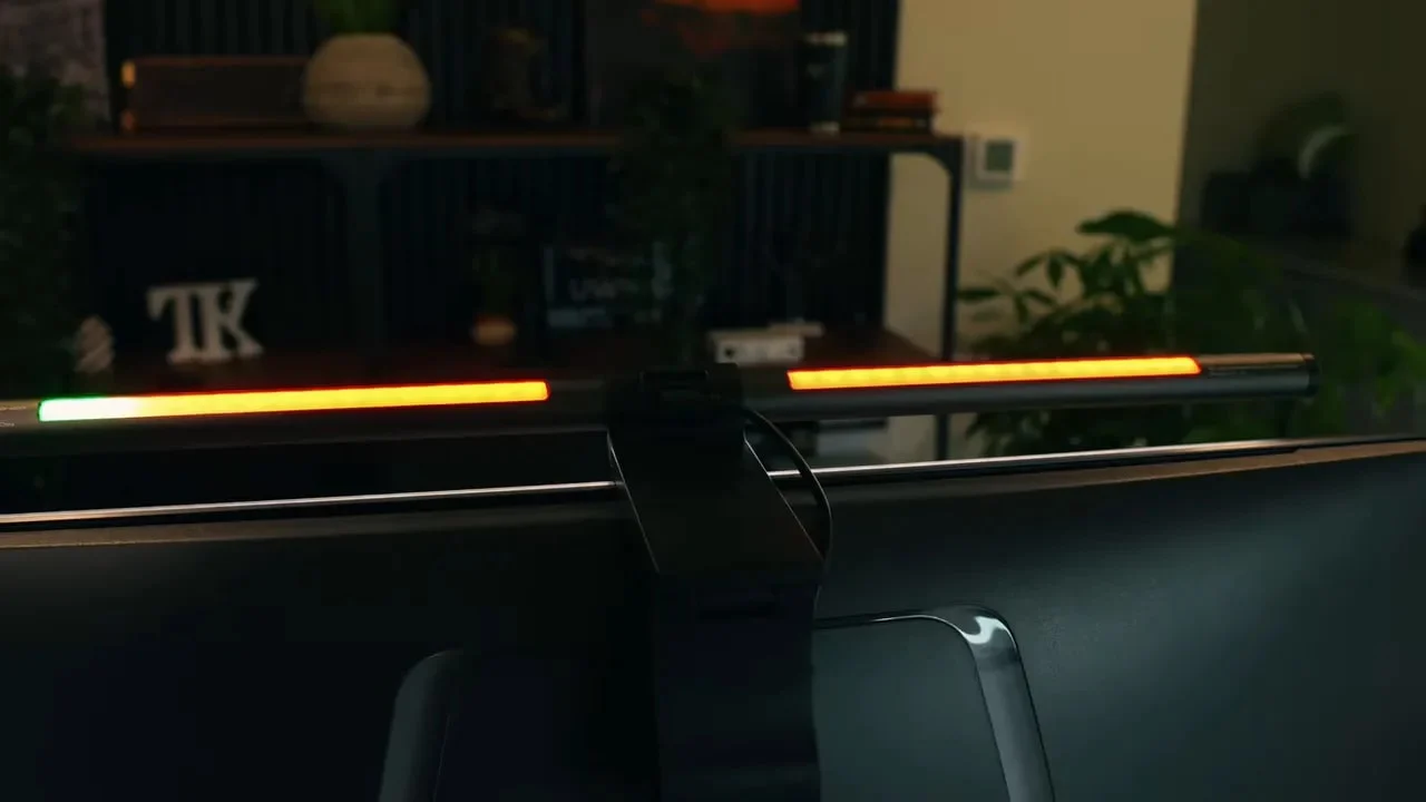 Rear RGB light bar glowing green and orange behind a monitor