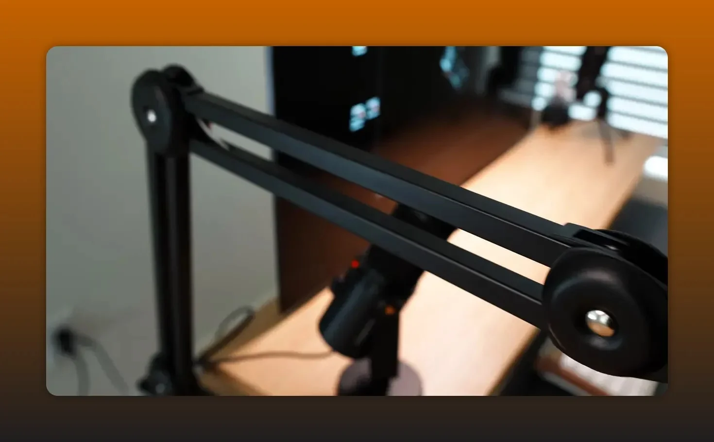 Close-up detail of a black adjustable microphone boom arm showing the parallel bars and joint