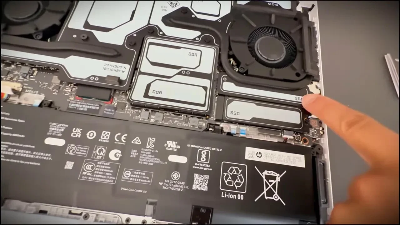Finger pointing to the SSD label and M.2 area beside the cooling fan inside an HP Omen Max 16
