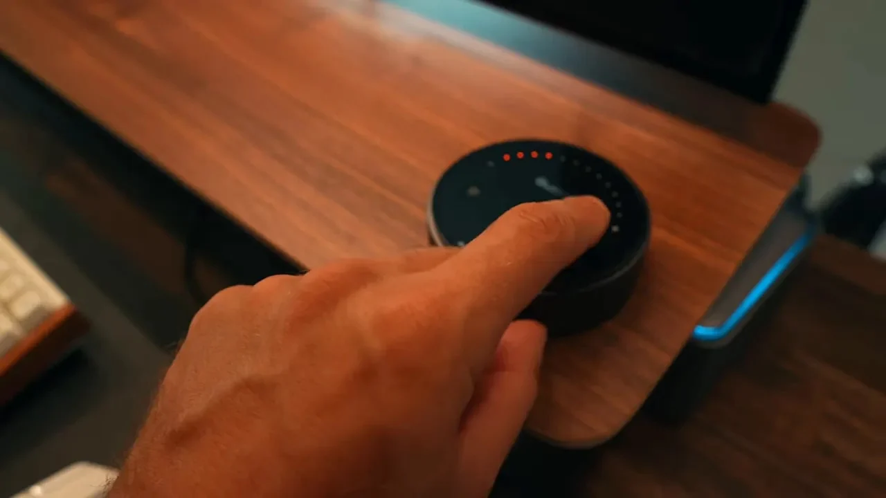 Hand using circular touch controller on desk beside keyboard