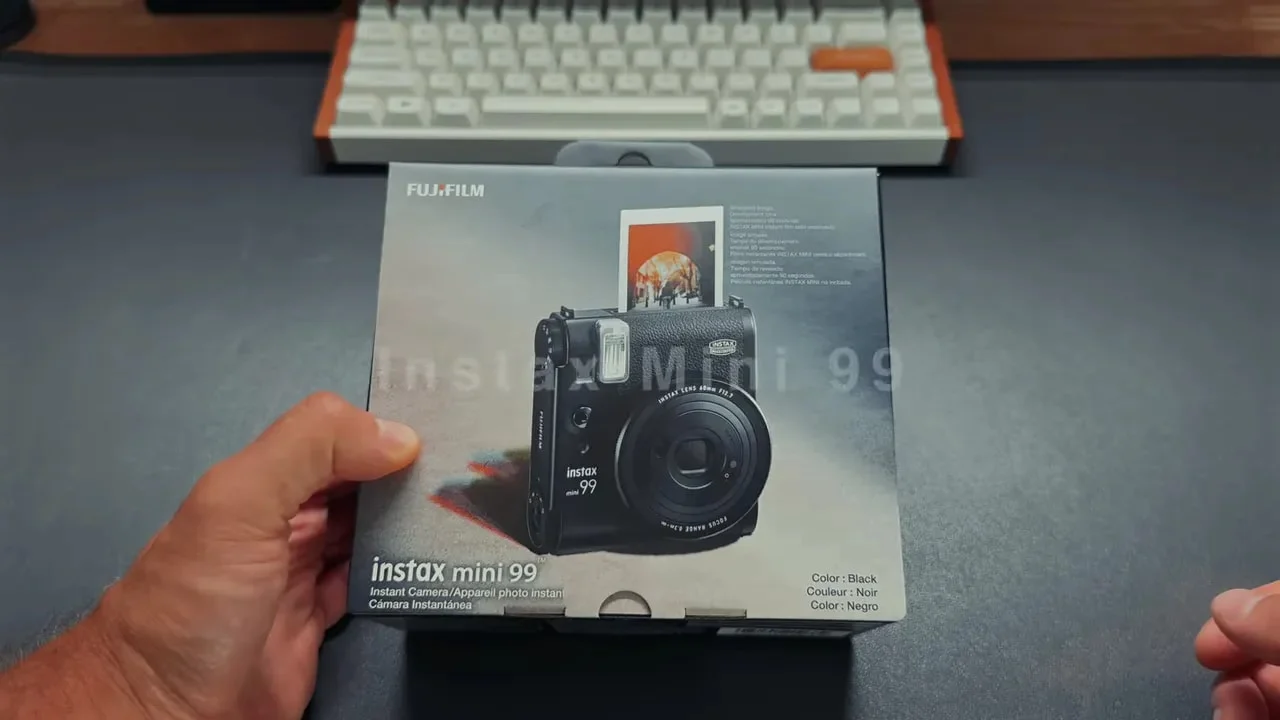 Instax Mini 99 retail box on desk with product image on front