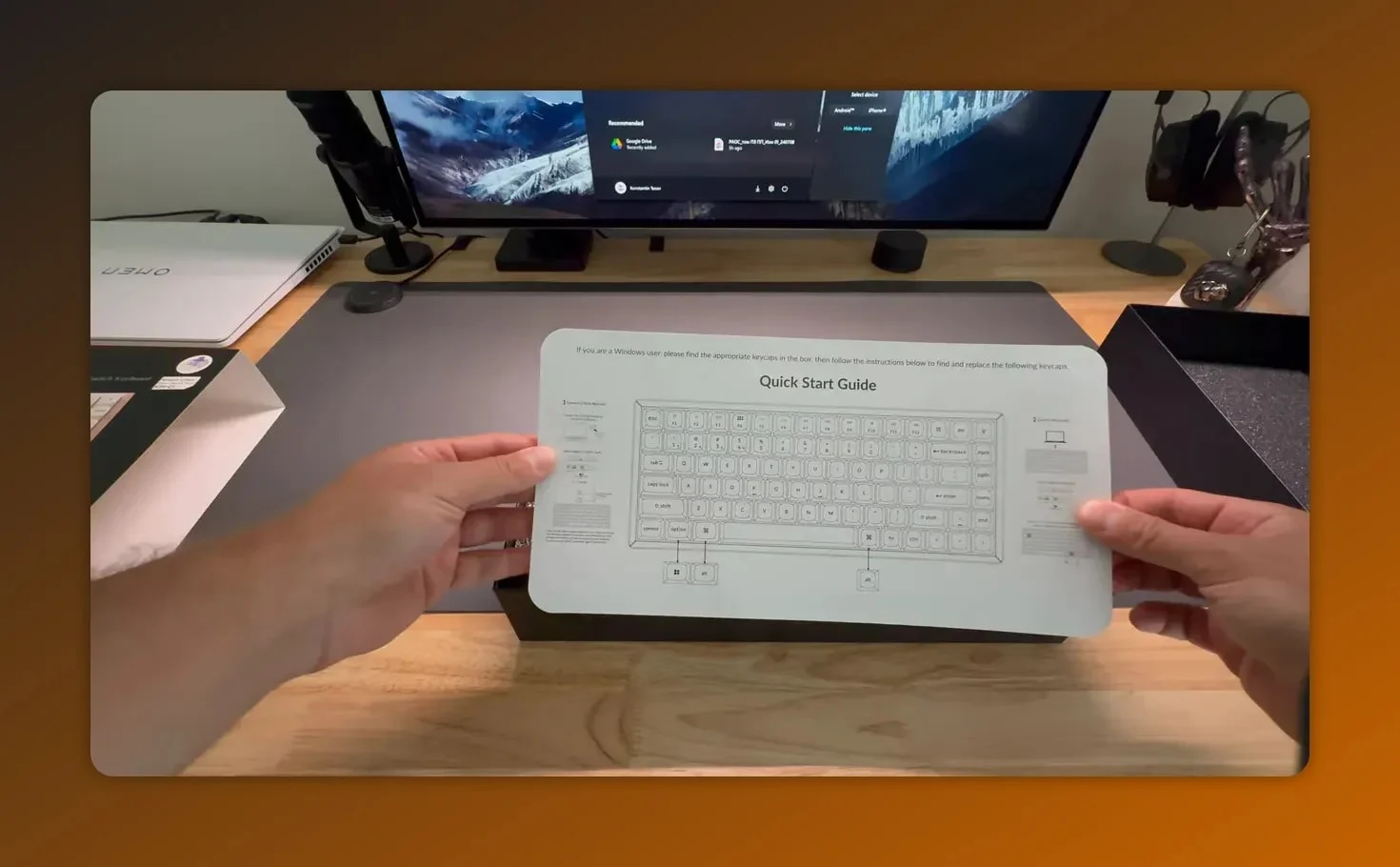 Keychron K2 HE quick start guide held up above the opened box showing keyboard layout diagram